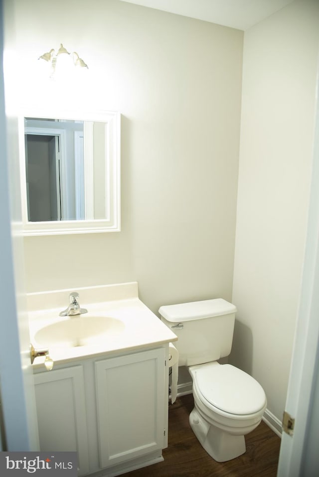 bathroom with hardwood / wood-style flooring, vanity, and toilet