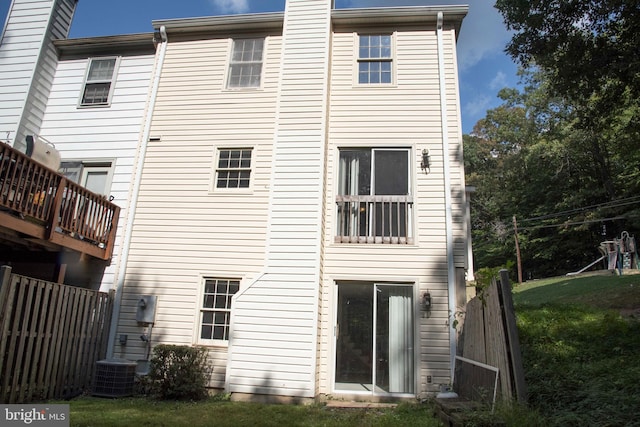 back of house with a yard and central air condition unit