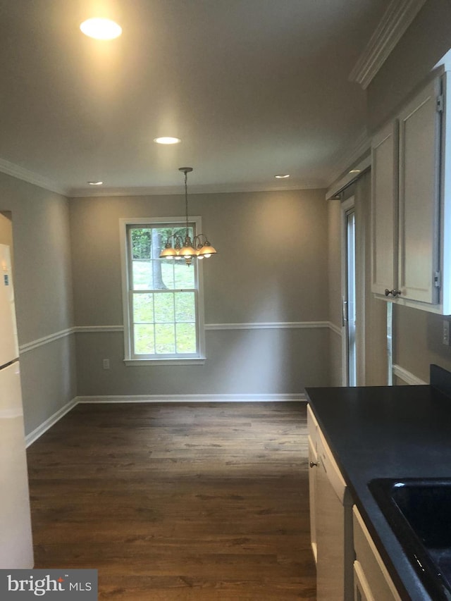 kitchen featuring white appliances, crown molding, dark hardwood / wood-style floors, a notable chandelier, and white cabinetry