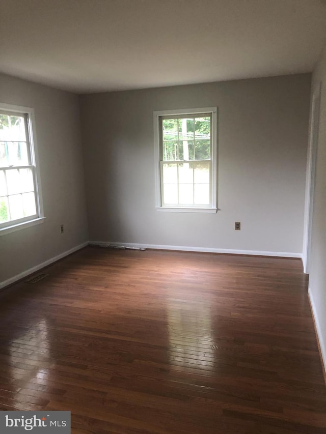 unfurnished room featuring dark wood-type flooring