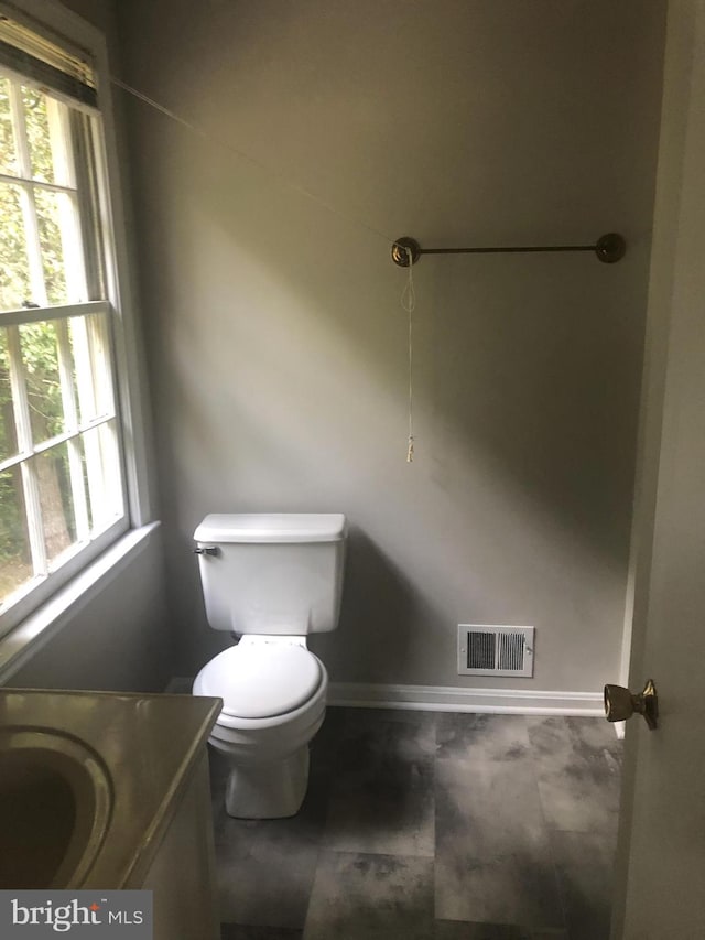 bathroom with plenty of natural light, vanity, and toilet