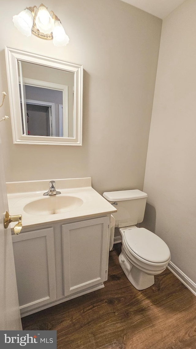 bathroom with vanity, wood-type flooring, and toilet