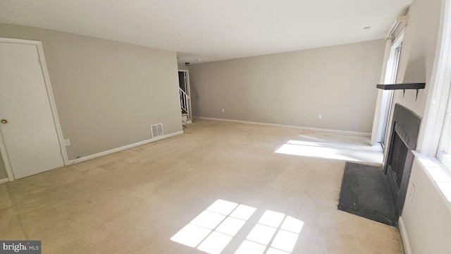 unfurnished living room with light colored carpet