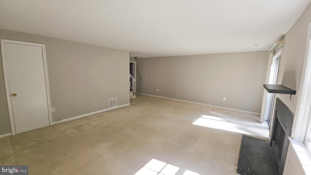 unfurnished living room featuring light colored carpet