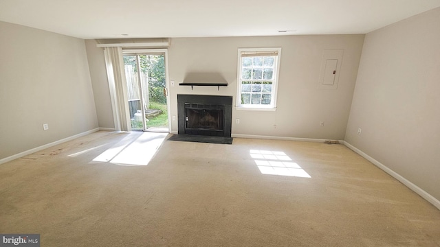 unfurnished living room with electric panel, plenty of natural light, and light colored carpet