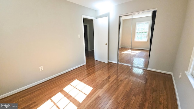 unfurnished bedroom with a closet and wood-type flooring