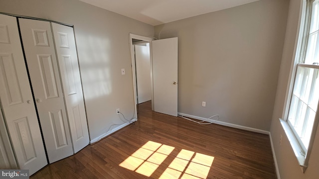 unfurnished bedroom featuring dark hardwood / wood-style floors and a closet