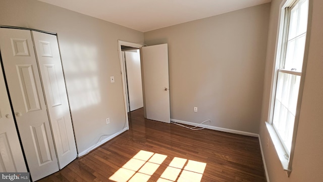 unfurnished bedroom with a closet and dark hardwood / wood-style floors