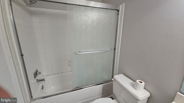 bathroom featuring shower / bath combination with glass door and toilet