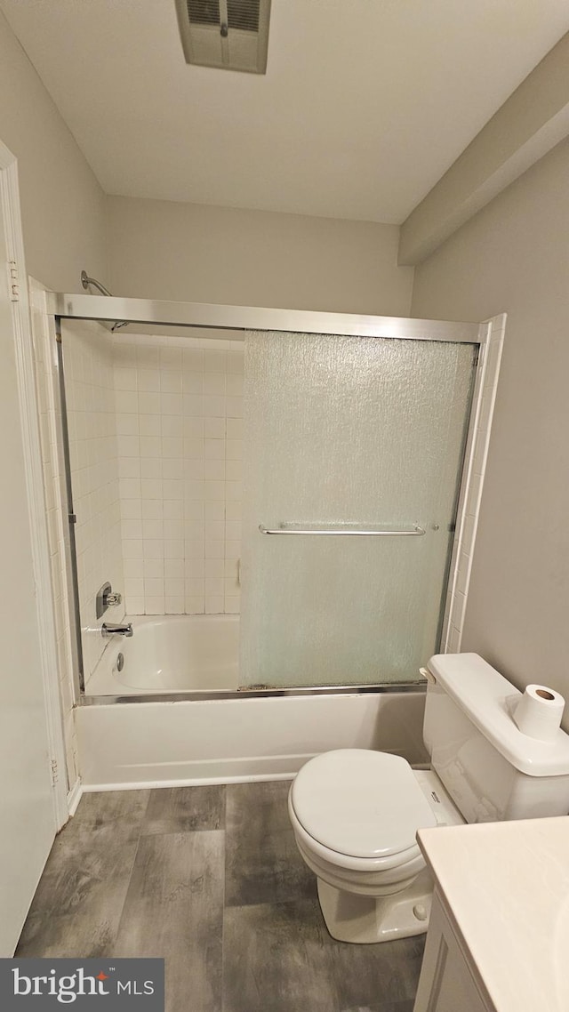 full bathroom with vanity, toilet, and bath / shower combo with glass door