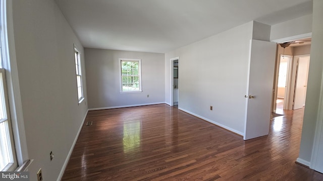 unfurnished room with dark wood-type flooring