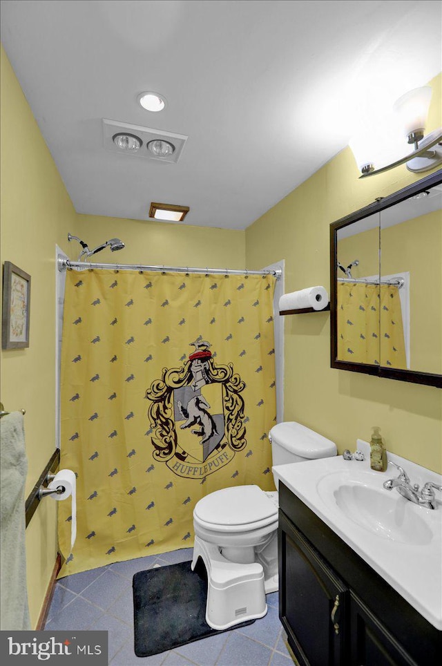 bathroom featuring tile patterned floors, vanity, toilet, and walk in shower