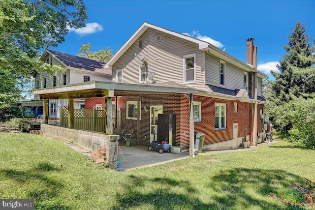 back of property featuring a lawn and a patio area