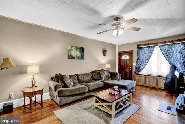 living room with radiator heating unit, hardwood / wood-style flooring, and ceiling fan