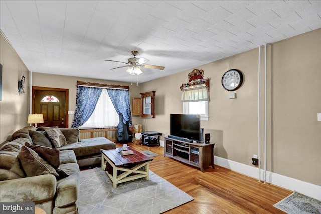 living room featuring radiator, ceiling fan, plenty of natural light, and parquet floors