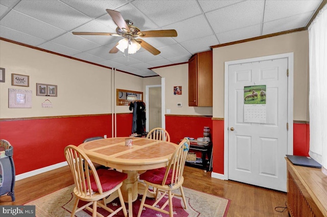 dining area with a paneled ceiling, ceiling fan, light hardwood / wood-style floors, and ornamental molding