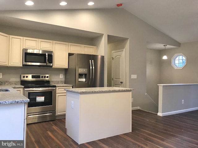 kitchen with appliances with stainless steel finishes, lofted ceiling, hanging light fixtures, a kitchen island, and white cabinets