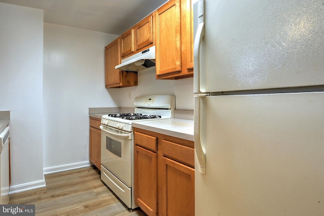 kitchen featuring white appliances and light hardwood / wood-style flooring