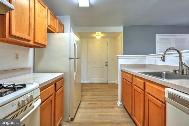 kitchen featuring light wood-type flooring, sink, and white appliances