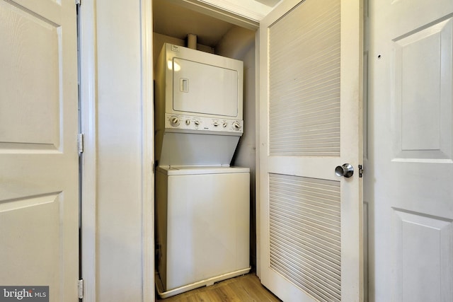 washroom featuring light hardwood / wood-style floors and stacked washer / drying machine