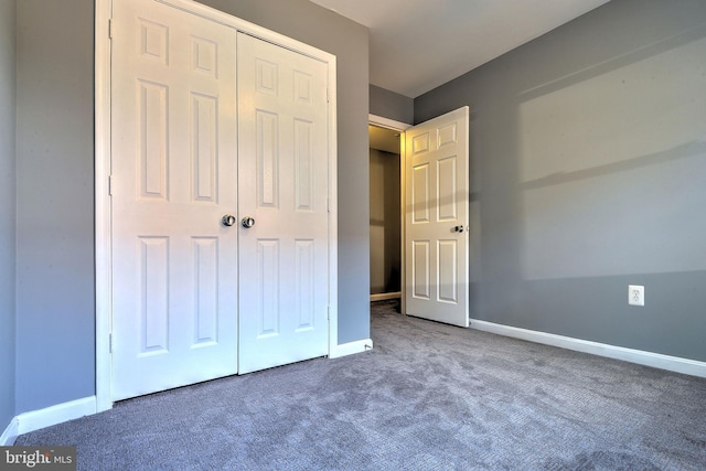 unfurnished bedroom featuring a closet and dark colored carpet