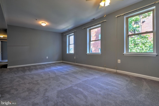 spare room with ceiling fan, a wealth of natural light, and carpet flooring