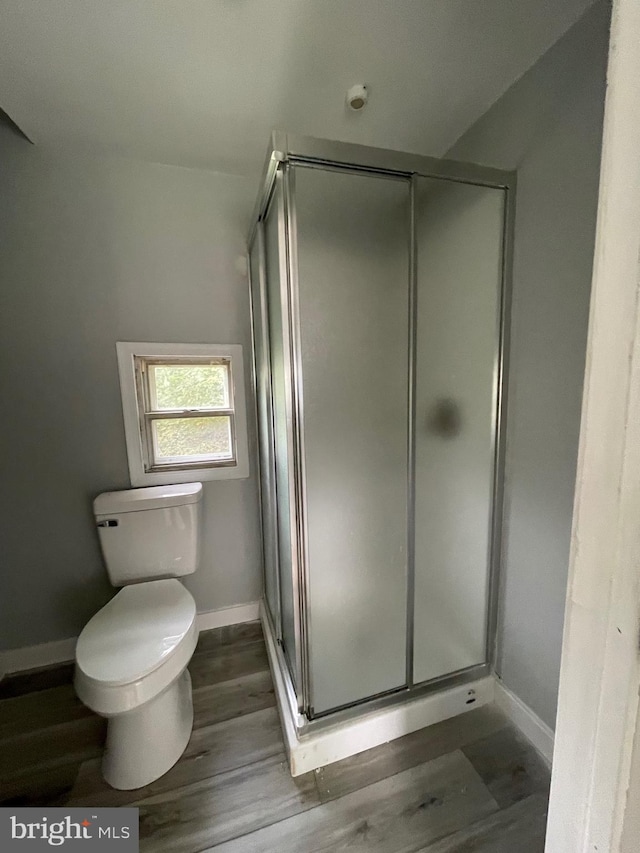 bathroom with hardwood / wood-style floors, toilet, and walk in shower