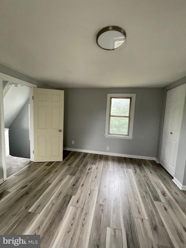 interior space with light hardwood / wood-style floors and vaulted ceiling