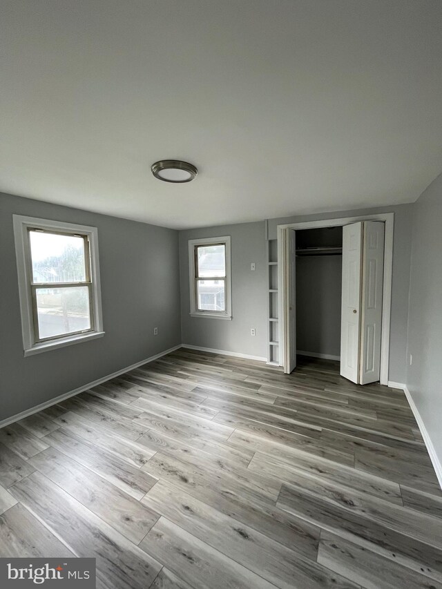 unfurnished bedroom with a closet and wood-type flooring