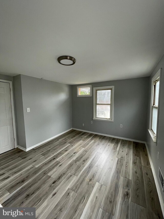 unfurnished room with hardwood / wood-style flooring