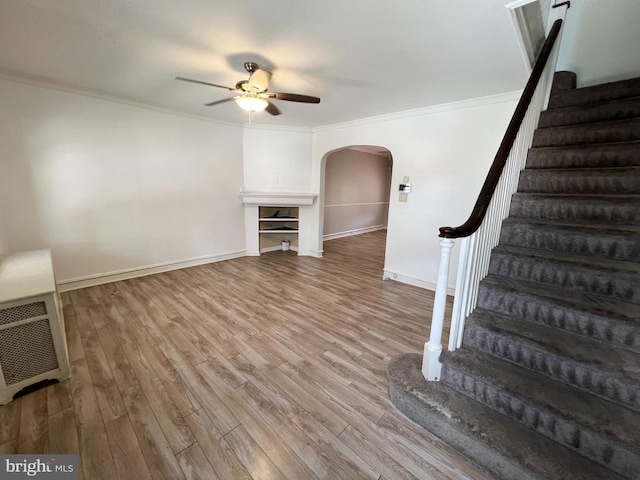 unfurnished living room featuring ceiling fan, light hardwood / wood-style flooring, and ornamental molding