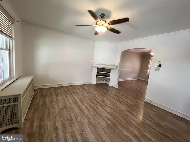 unfurnished living room with wood-type flooring, crown molding, and ceiling fan