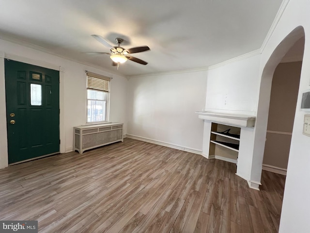 unfurnished living room with ornamental molding, hardwood / wood-style floors, and ceiling fan