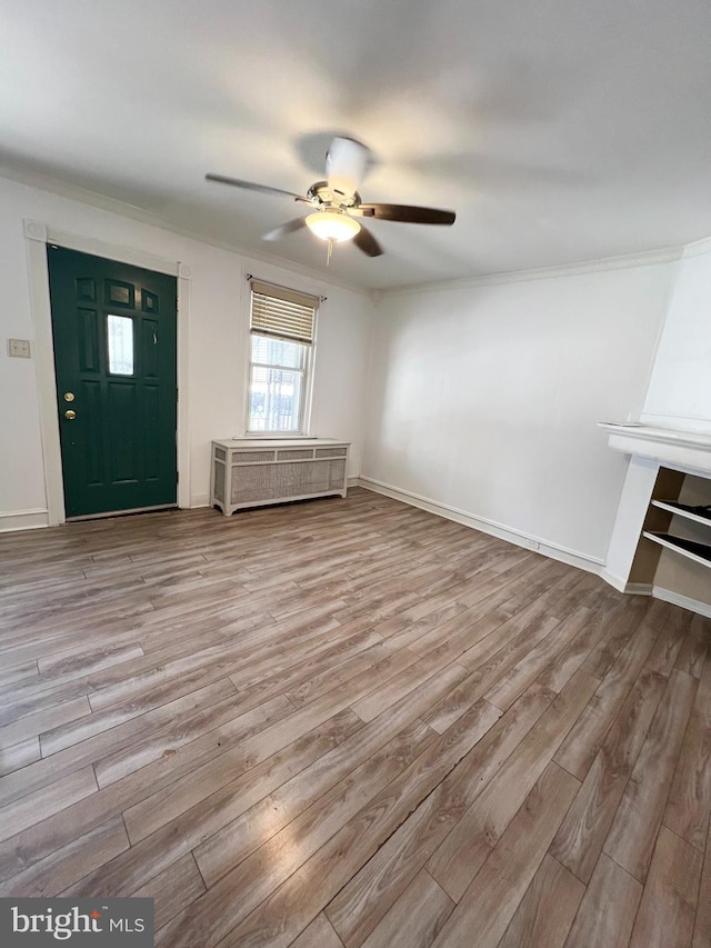 unfurnished living room featuring crown molding, ceiling fan, and hardwood / wood-style floors