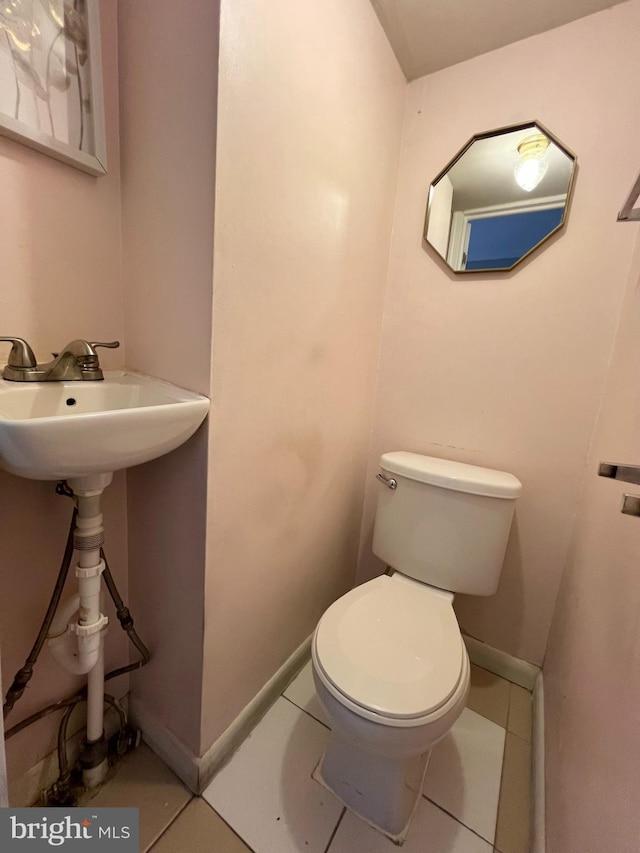 bathroom with toilet and tile patterned floors