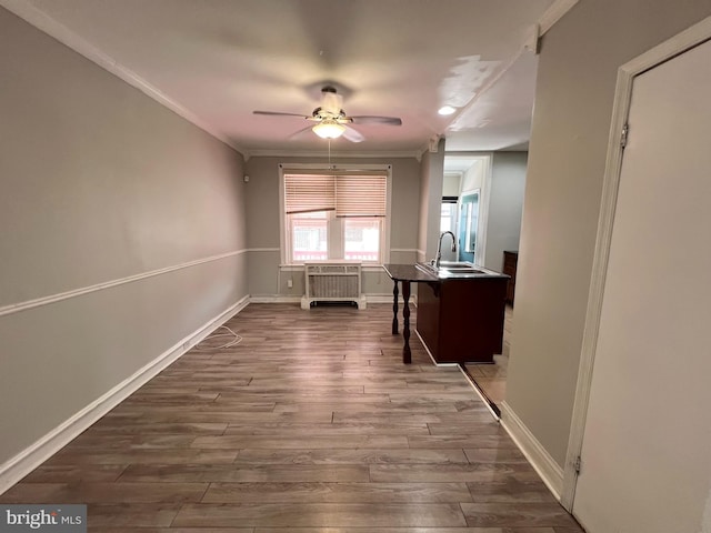 hallway with sink, crown molding, and wood-type flooring