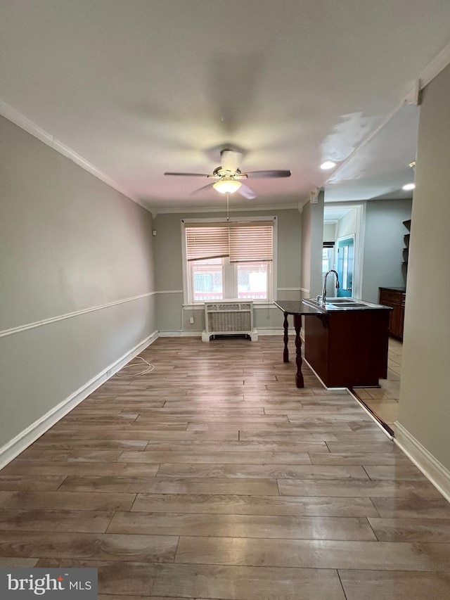 interior space with sink, crown molding, ceiling fan, and wood-type flooring