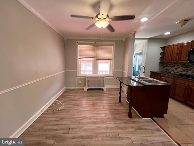 kitchen with black appliances, decorative backsplash, crown molding, sink, and light hardwood / wood-style flooring