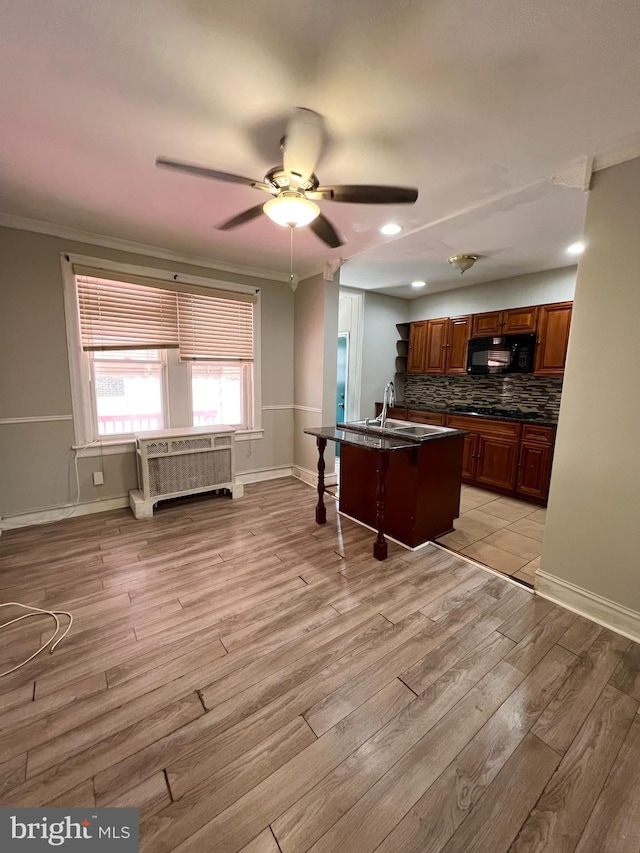 kitchen with light hardwood / wood-style flooring, sink, decorative backsplash, ceiling fan, and ornamental molding