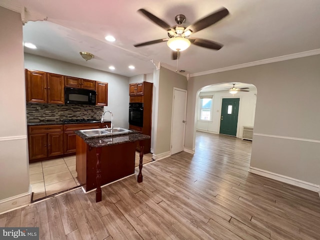 kitchen featuring sink, light hardwood / wood-style flooring, ceiling fan, and black appliances