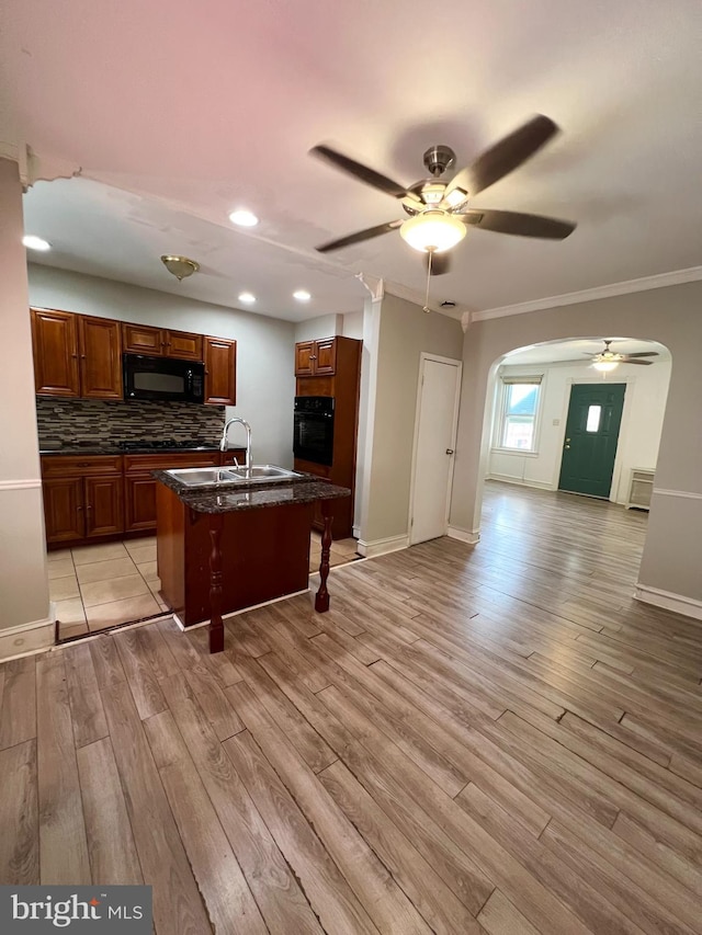 kitchen with light hardwood / wood-style floors, black appliances, sink, and ceiling fan