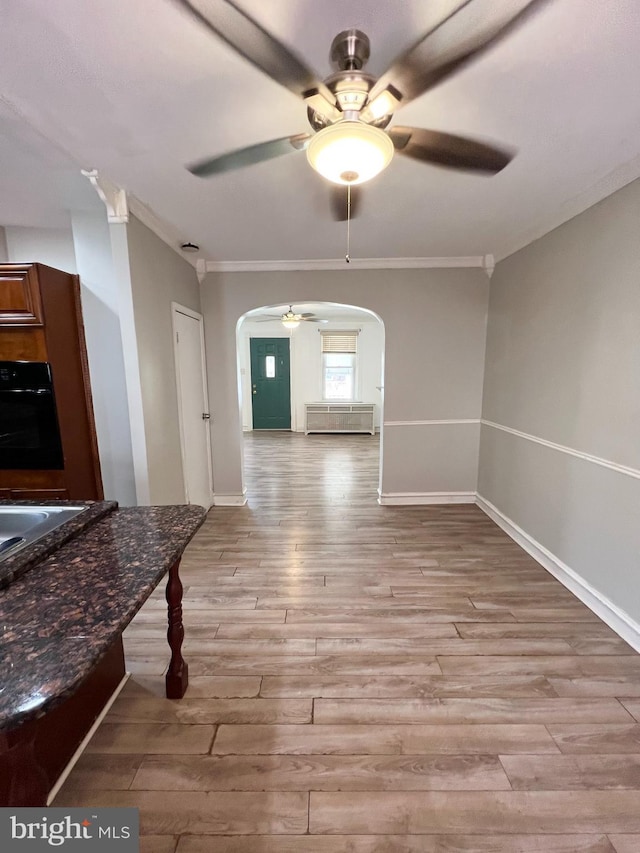 interior space with crown molding, ceiling fan, and light hardwood / wood-style floors