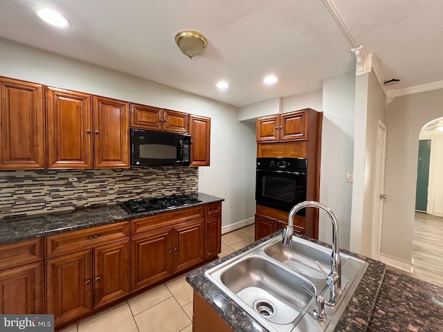 kitchen featuring tasteful backsplash, black appliances, sink, light tile patterned floors, and crown molding