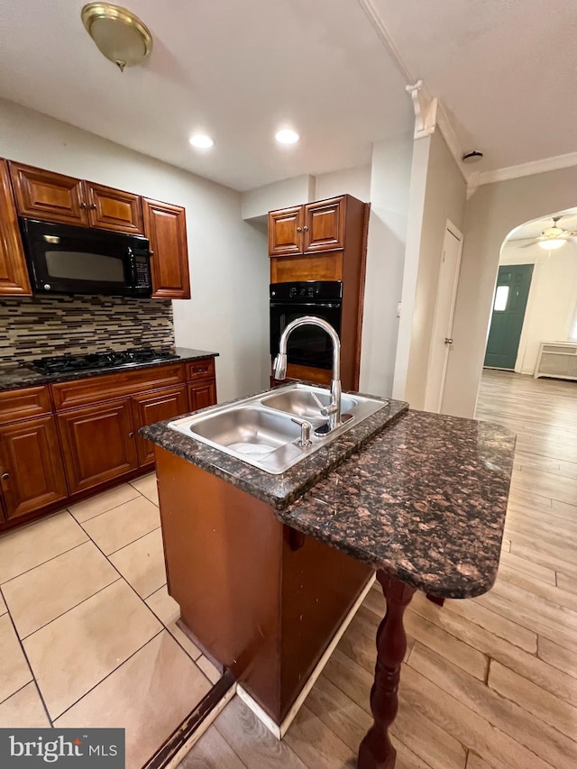 kitchen featuring black appliances, tasteful backsplash, ceiling fan, ornamental molding, and light hardwood / wood-style floors