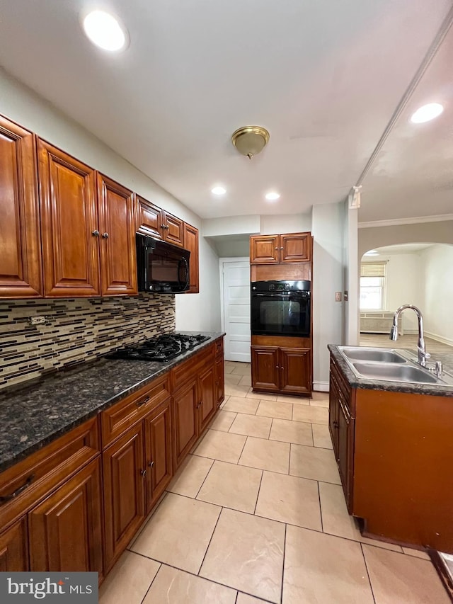 kitchen featuring light tile patterned flooring, backsplash, black appliances, and sink