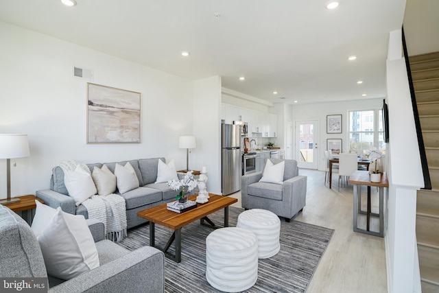 living room with light hardwood / wood-style flooring and sink