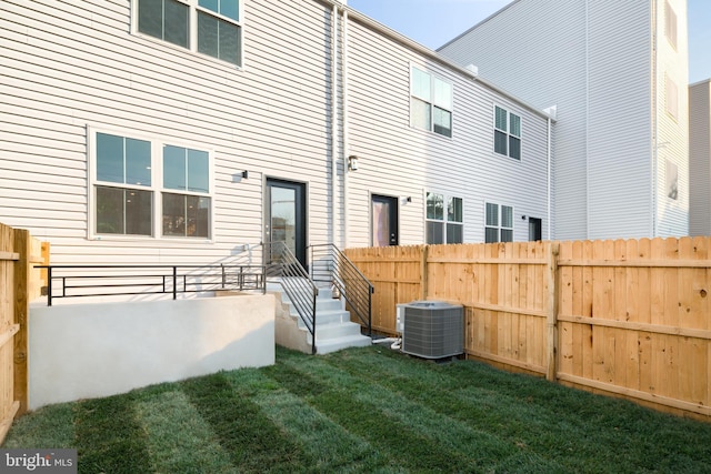 back of house with a lawn and cooling unit