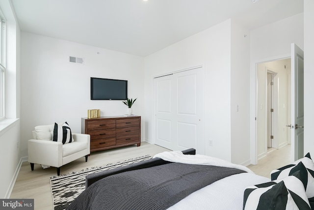 bedroom with light hardwood / wood-style flooring and a closet