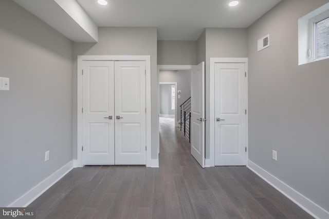 unfurnished bedroom with a closet and dark wood-type flooring