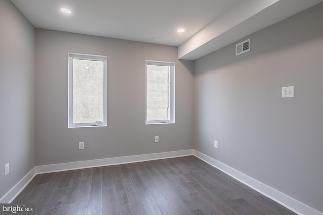 unfurnished room featuring dark hardwood / wood-style floors and a healthy amount of sunlight